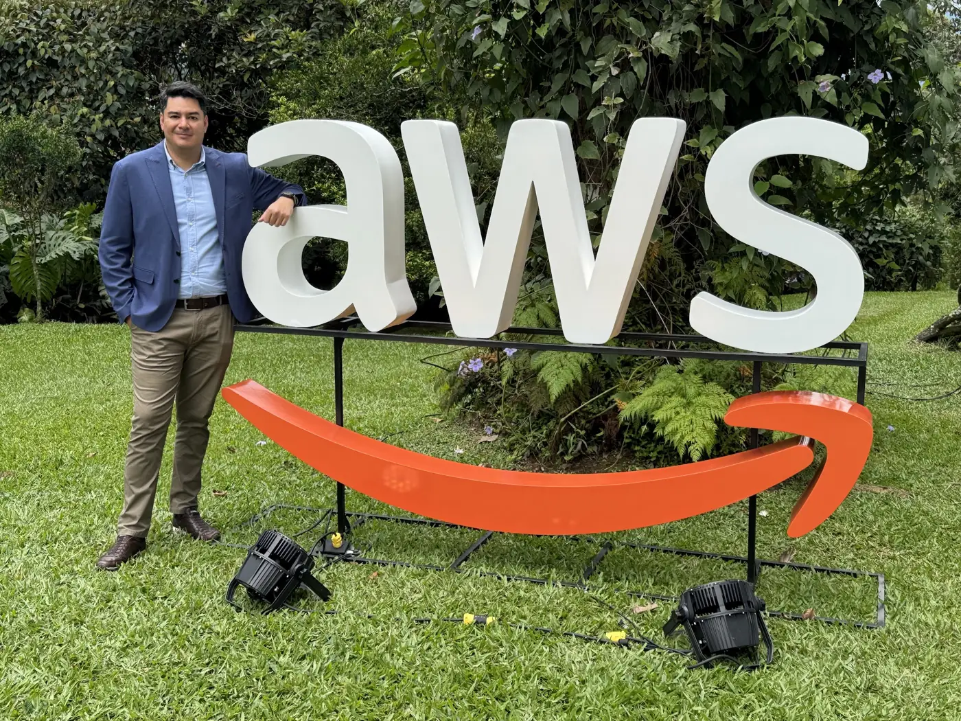 Integrante de TrailStart junto al logo de AWS en un evento de AWS