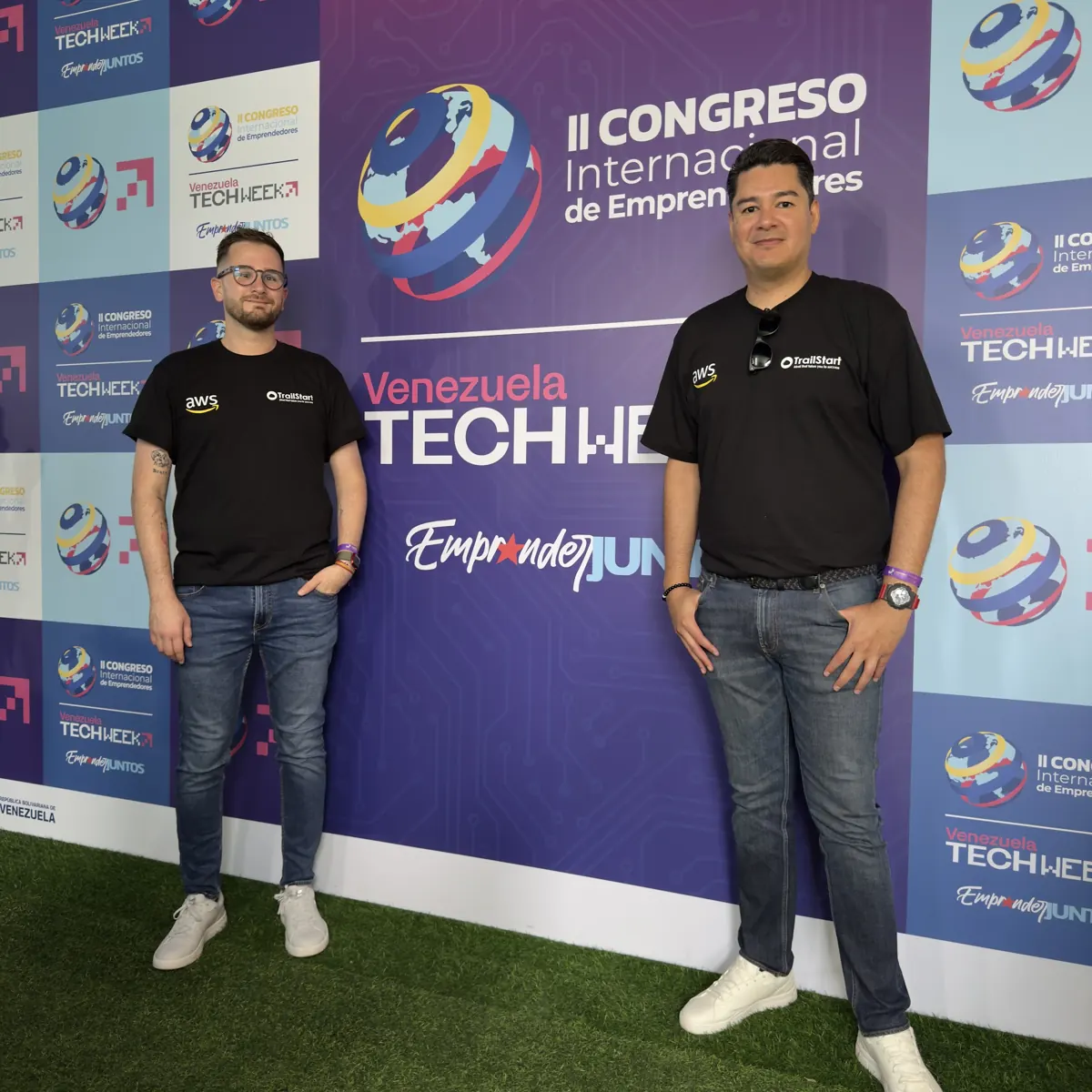 Dos integrantes de TrailStart con camisetas de TrailStart y AWS en Venezuela Tech Week