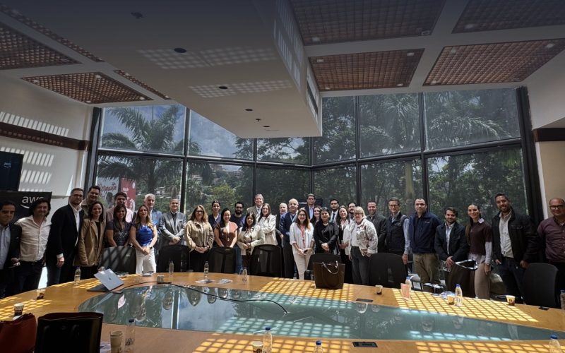 Asistentes del Caracas Health Leaders Summit en la sala de reuniones, junto a los logos de TrailStart y AWS